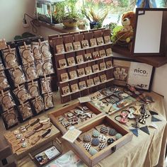 an assortment of buttons and magnets on display in a store window with wooden boxes