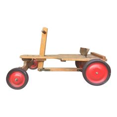 a wooden toy with red wheels on a white background