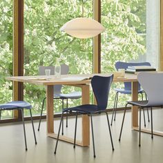 a dining room table with four chairs and a vase on the table next to it