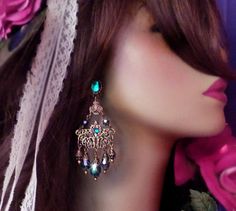 "These Victorian Filigree Chandelier Earrings are made with *Peacock Teal crystal and ornate layered brass filigrees. A Swarovski rhinestone decorates the surface of the filigrees for an added sparkle! Available with Posts, Clip-Ons or French Wires. The pictures show the post version. If french wire are chosen this top Aqua stone will be omitted from the design. -3 1/2\" Long x 1 3/8\" Wide -0.3 oz. ea. -Free Ship! (Domestic) -Many Colors Available! *Comes Ready To Gift in Decorative Packaging * Bohemian Jeweled Chandelier Earrings As Gift, Bohemian Green Chandelier Earrings For Wedding, Bohemian Jeweled Dangle Chandelier Earrings, Bohemian Pierced Chandelier Earrings For Wedding, Bohemian Chandelier Earrings With Filigree For Parties, Turquoise Bohemian Chandelier Earrings For Party, Bohemian Turquoise Chandelier Earrings For Party, Peacock Teal, Victorian Filigree