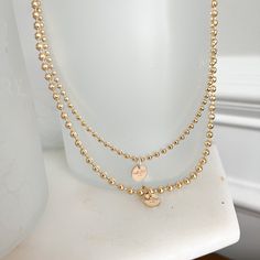 This Logo Ball Chain Gold Necklace brings a modern twist to a timeless classic. Its signature logo charm sits atop a water-resistant gold ball chain, creating a sophisticated and exclusive accessory perfect for making a statement and displaying unique style. Measures 16” Logo charm is 14 karat gold filled. Choose small ball chain or medium ball chain size. Comes boxed. Made in USA. Gold-tone Gold-plated Satellite Chain Necklace, Everyday Gold Ball Chain Necklace, Gold-tone Satellite Chain Necklace, Gold Plated Charm Necklace With Satellite Chain, Gold-plated Ball Chain Necklace, Perfect As A Gift, Gold Plated Charm Necklaces With Satellite Chain, Gold-plated Gold Charm Necklace With Satellite Chain, Gold Plated Gold Charm Necklace With Satellite Chain, Gold Charm Necklace With Satellite Chain For Everyday