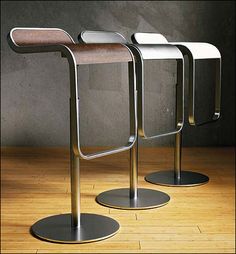 three metal stools sitting on top of a wooden floor