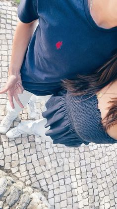 a woman standing on top of a cobblestone road