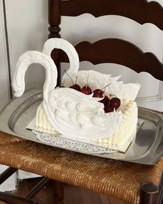 a cake sitting on top of a metal tray covered in icing and cherries