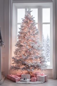 a white christmas tree with presents under it