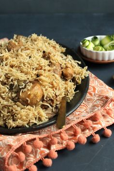 a black plate topped with rice and meat