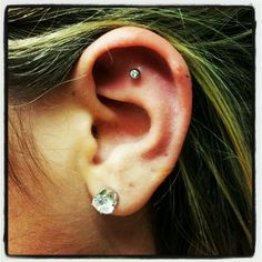 a close up of a person's ear with two piercings