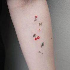 small cherry tattoo on the left arm