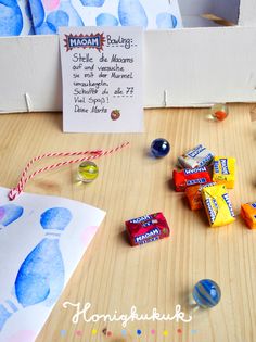 some candy is laying on the table next to a note