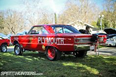 an old red car with the word plymouth painted on it