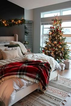 a bedroom decorated for christmas with a tree in the corner and plaid blankets on the bed