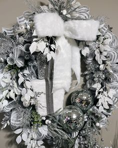 a christmas wreath with white and silver decorations