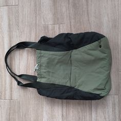 a green and black bag sitting on top of a wooden floor