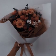 a bouquet of flowers wrapped in brown paper