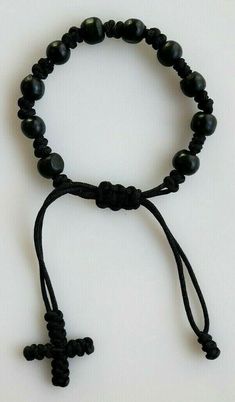 a black beaded bracelet with a cross on it