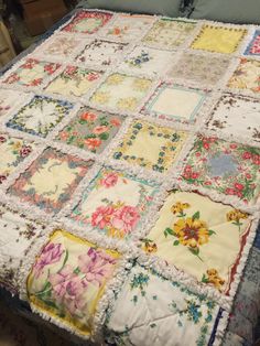 a quilted table cloth with flowers and laces on it, sitting on top of a bed