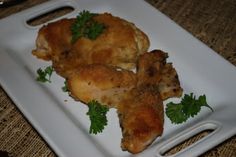 two pieces of chicken on a plate with parsley