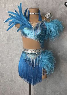 a blue and silver costume on a mannequin with feathers attached to the chest