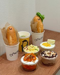 there are many different types of food in cups on the table, including breads and puddings