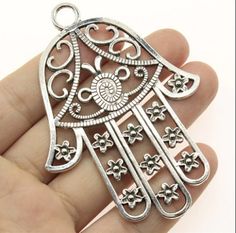 This adorable pendant charms is made from zinc alloy metal and are lead and nickel free. It's perfect for crafting necklaces, bracelets, earrings, bookmarks, key chains and more! ♥ Antique Silver Tone Large Hamsa Hand Pendant Charm ♥ Material: Zinc Alloy Metal ♥ Size: 85x 62mm ♥ Includes: piece We ship on the next business day from North Carolina via USPS. Tracking is included with all orders. Get free shipping on orders over 35! Don't forget to favorite us too, we add items daily. Thank you... Pagan Pendants, Moroccan Jewelry, Hand Pendant, Gold Gift Boxes, Hamsa Pendant, Zodiac Bracelet, Hamsa Hand, Diy Pendant, Fashion Jewelry Necklaces