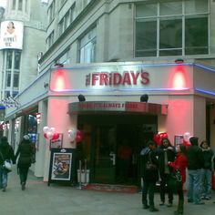 people are standing outside of a restaurant called friday's it's always friday