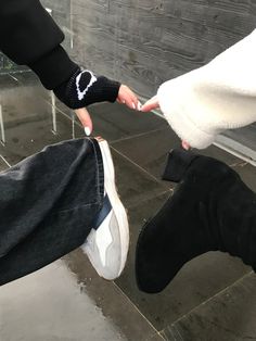 two people holding hands while standing next to each other