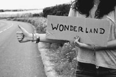 a woman holding a sign that says wonderland