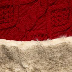 a red knitted sweater with white fur on the bottom and side, close up