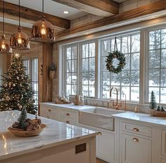 a christmas tree is in the middle of a kitchen with white cabinets and counter tops