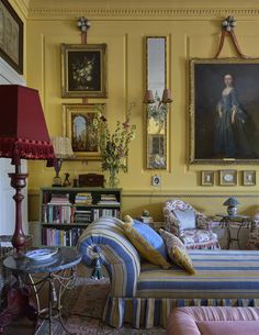 a living room filled with furniture and paintings on the wall