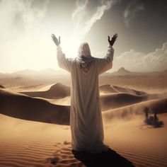 a person standing in the desert with their hands up and arms outstretched to the sky