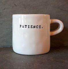 a white coffee mug with the words patience on it