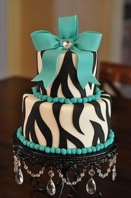 the cake is decorated with zebra stripes and turquoise beads