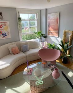 a living room filled with lots of furniture and decor on top of a hard wood floor