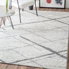 a living room area with a rug, chair and table on the hardwood flooring