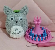 a stuffed animal sitting next to a hairbrush on a pink surface with other items