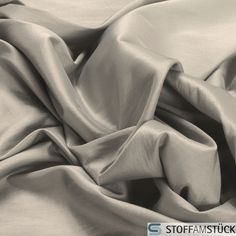 an unmade bed with white sheets on top of it and a black and white photo