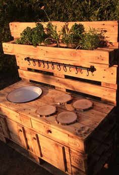 an outdoor kitchen made out of pallets and wooden boards with plants growing on top