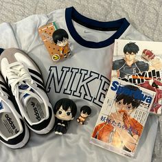 an assortment of anime items are laid out on a bed next to a t - shirt