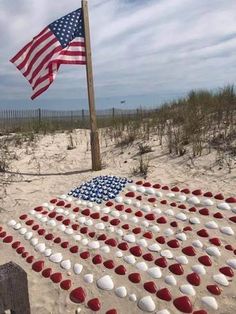 an american flag made out of shells on the beach