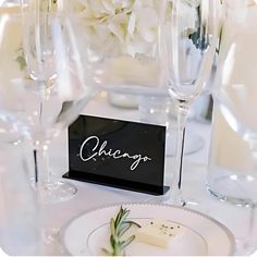 the table is set with white flowers and wine glasses