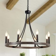 a chandelier hanging from the ceiling in a room with white walls and wood beams