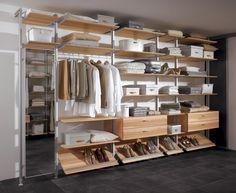 an organized closet with clothes and shoes on shelving units in the center, along with other storage bins