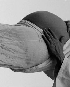 a pregnant woman holding her belly up to her chest