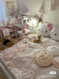 a bedroom with hello kitty bedding and stuffed animals on the bedspread in it