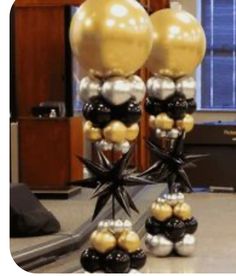 some black and gold balloons are on a table