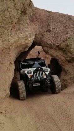 a jeep driving through a cave in the desert