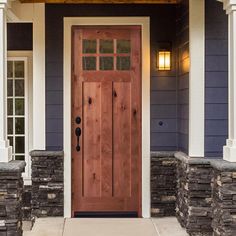 a wooden door on the side of a blue and white house with stone steps leading up to it