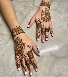 two hands with henna tattoos on them