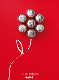 six cans of coca - cola are arranged in the shape of a flower on a red background